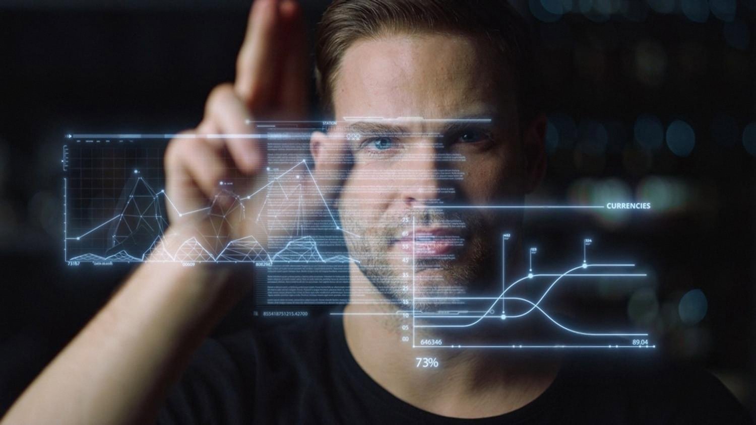 Analyst reviewing company data and currency charts on a transparent screen